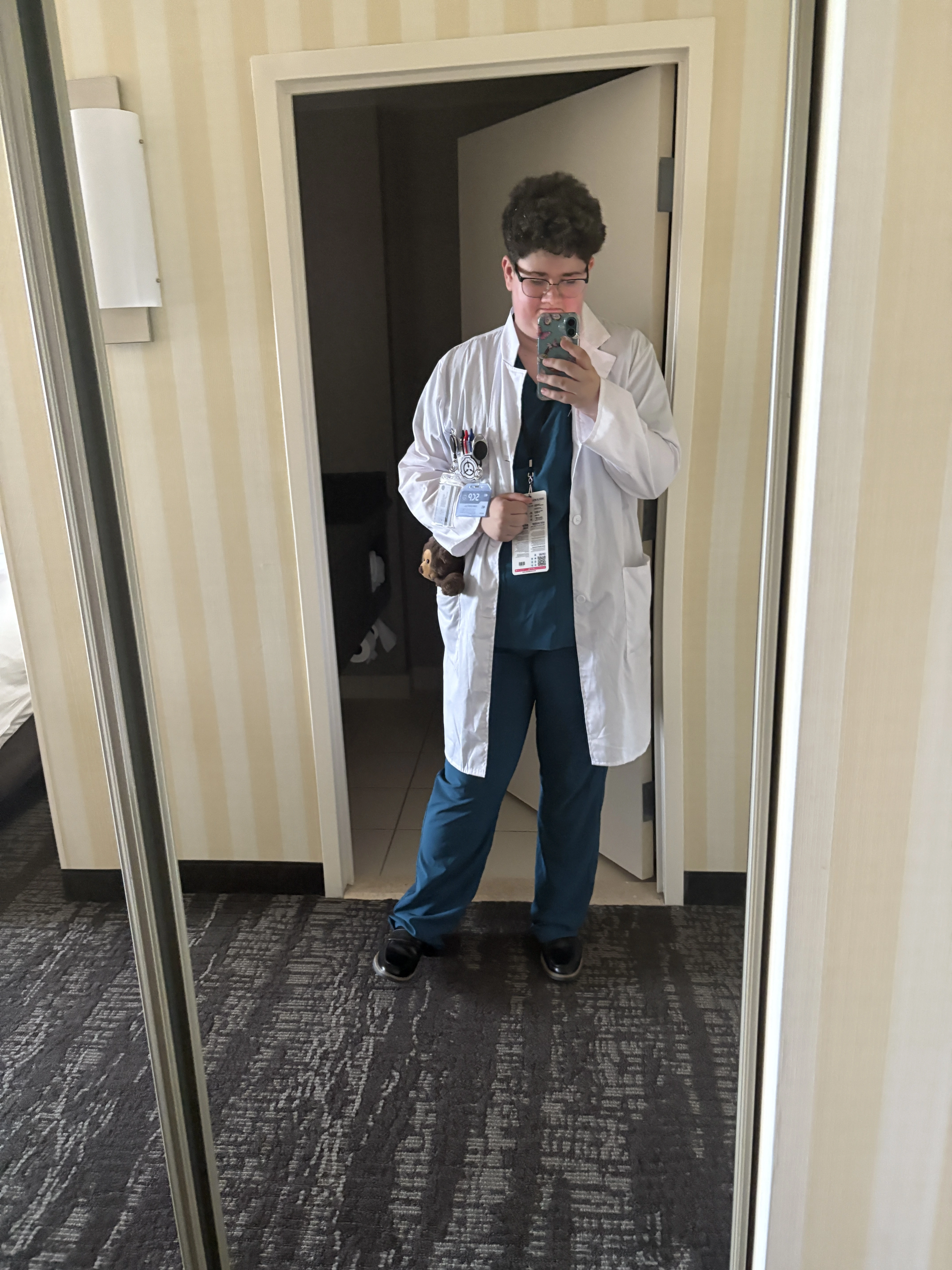 Mirror selfie of me in a white scientist jacket and green scrubs